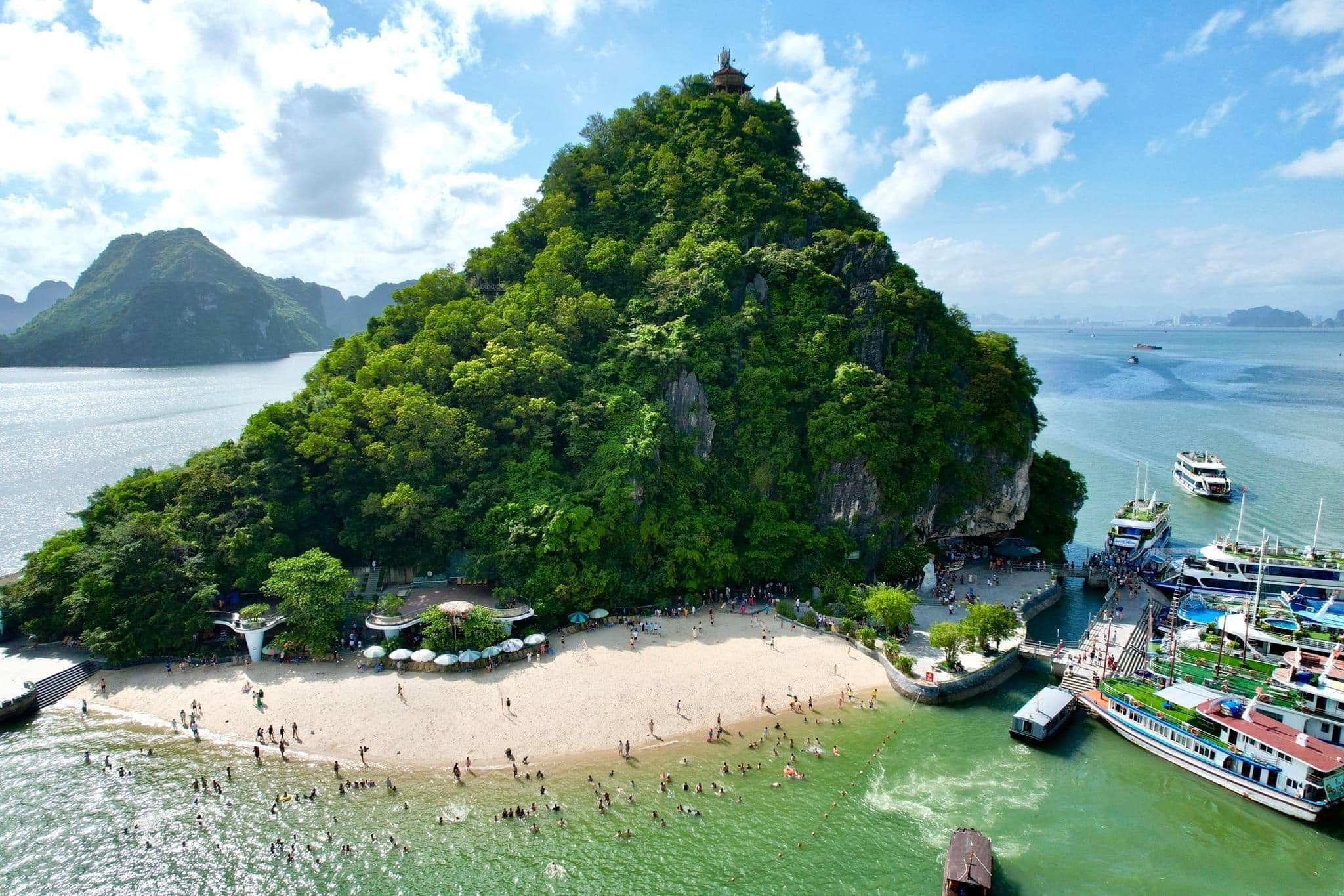 Titop Island stands out with its crescent-shaped beach and a mountaintop offering panoramic views of Ha Long Bay